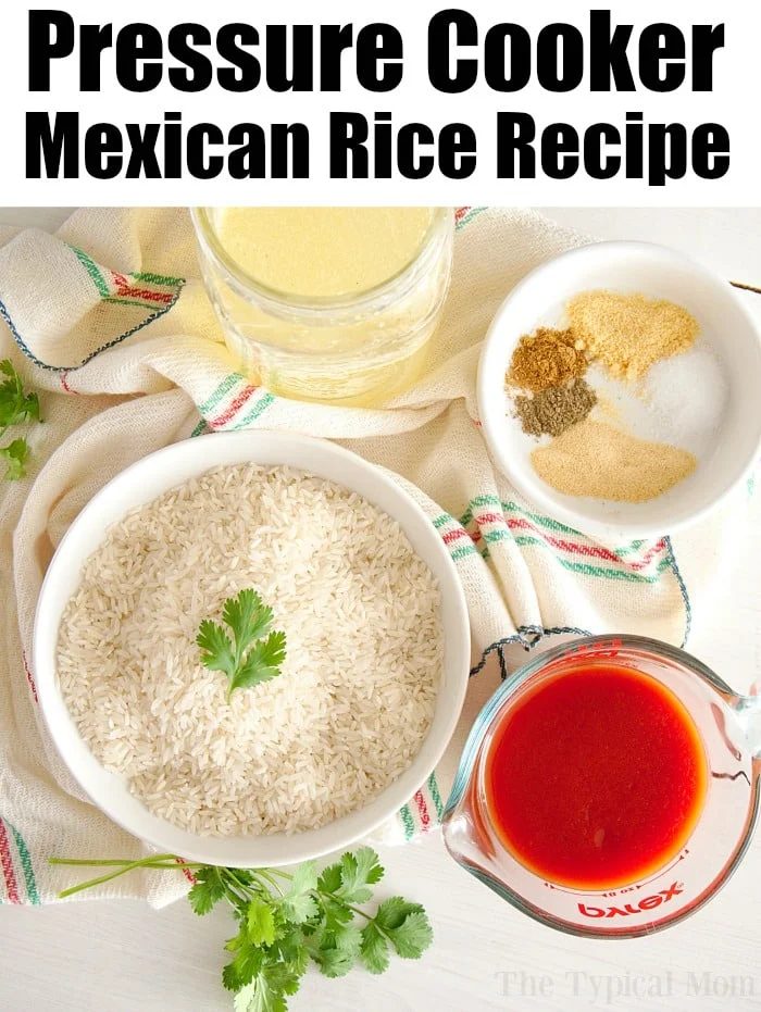 Ingredients for a pressure cooker Mexican rice recipe are neatly arranged: uncooked rice in a bowl, a measuring cup of tomato sauce, broth in a glass, and seasonings in a small bowl. A sprig of cilantro and a kitchen towel complete the scene. Text reads "Pressure Cooker Mexican Rice Recipe.
