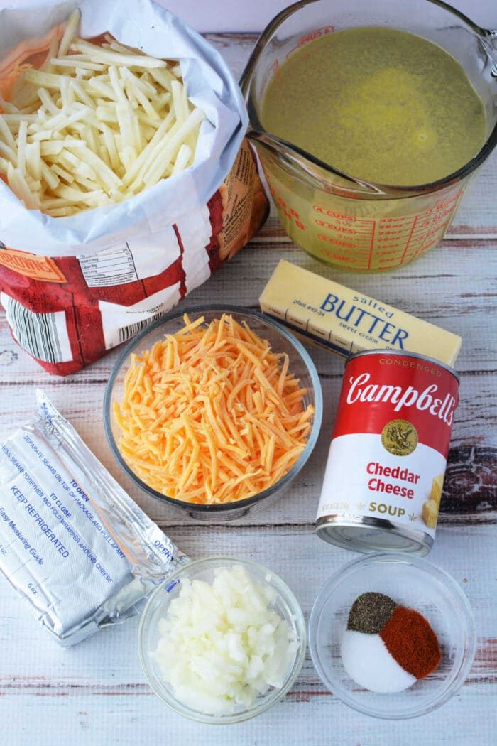 Ingredients for this delightful potato soup: frozen hash browns, butter, broth, shredded cheese, cream cheese, chopped onions, spices, and a soup can. Perfectly crafted in your pressure cooker for a cozy meal.