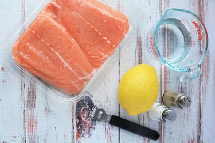 A good salmon recipe begins with raw fillets, a fresh lemon, and a measuring cup of water. Add salt and pepper for zest. Use a pressure cooker to infuse flavors effortlessly. Dont forget the black bottle opener nearby for your favorite refreshment.