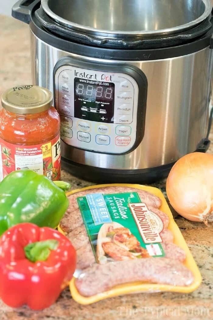 Pressure cooker sausage with marinara sauce, onion, green bell pepper, and red bell pepper sits on a kitchen counter for a quick and good meal.