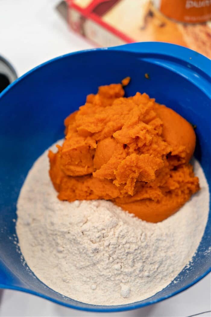 The blue bowl holds a delightful blend of cake mix and pumpkin puree, the solid base for crafting a batch of pumpkin bread with spice cake mix.