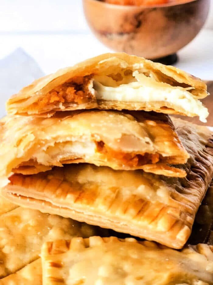 Air fryer pumpkin hand pies with a golden, flaky crust and a spiced pumpkin filling inside.