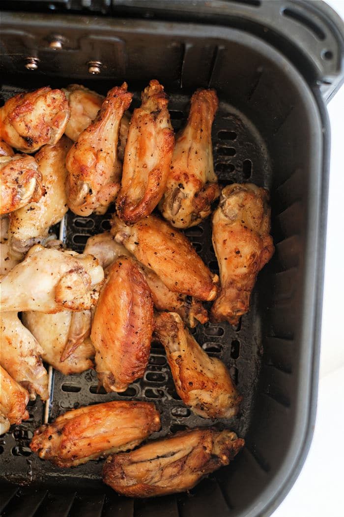 Savor the zest of lemon pepper chicken wings cooked to crispy perfection inside an air fryer basket.