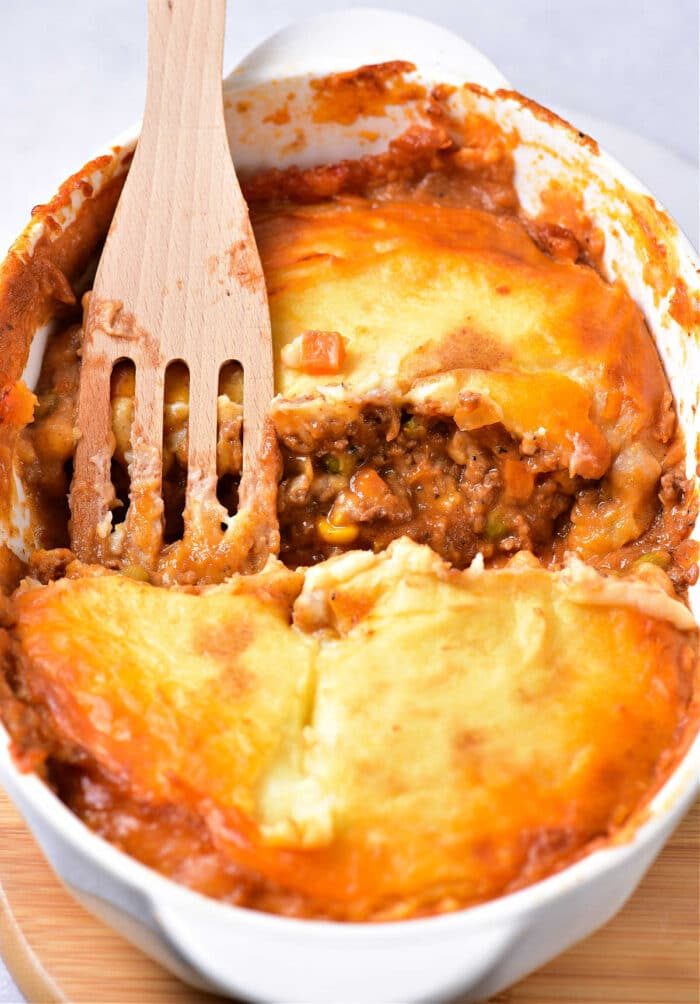 A wooden spatula serves comforting Shepherds Pie with ground turkey.
