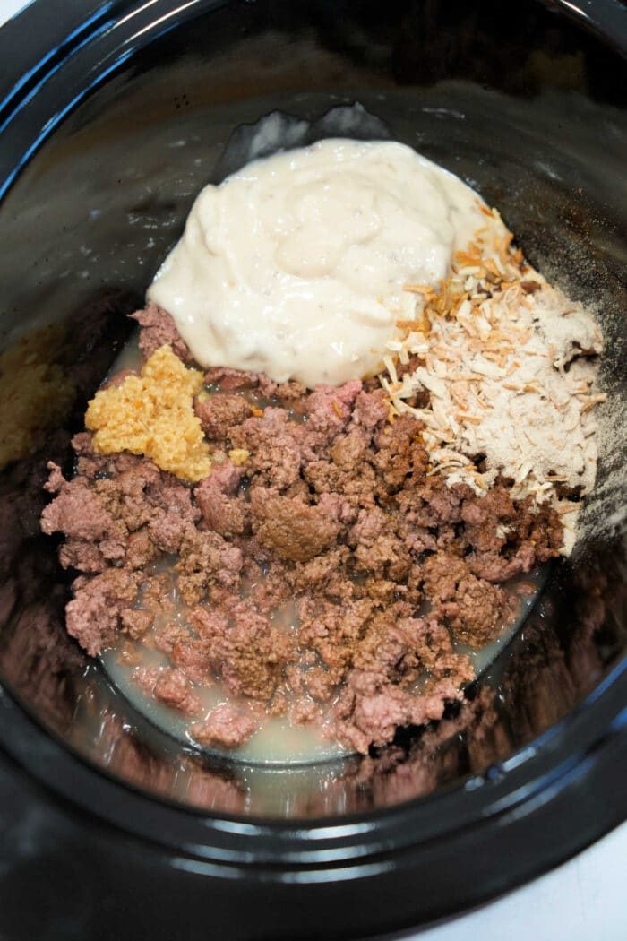 Ground beef, cream soup, onions, and seasonings combine in the slow cooker for an easy Ground Beef Stroganoff ready to be mixed and cooked.