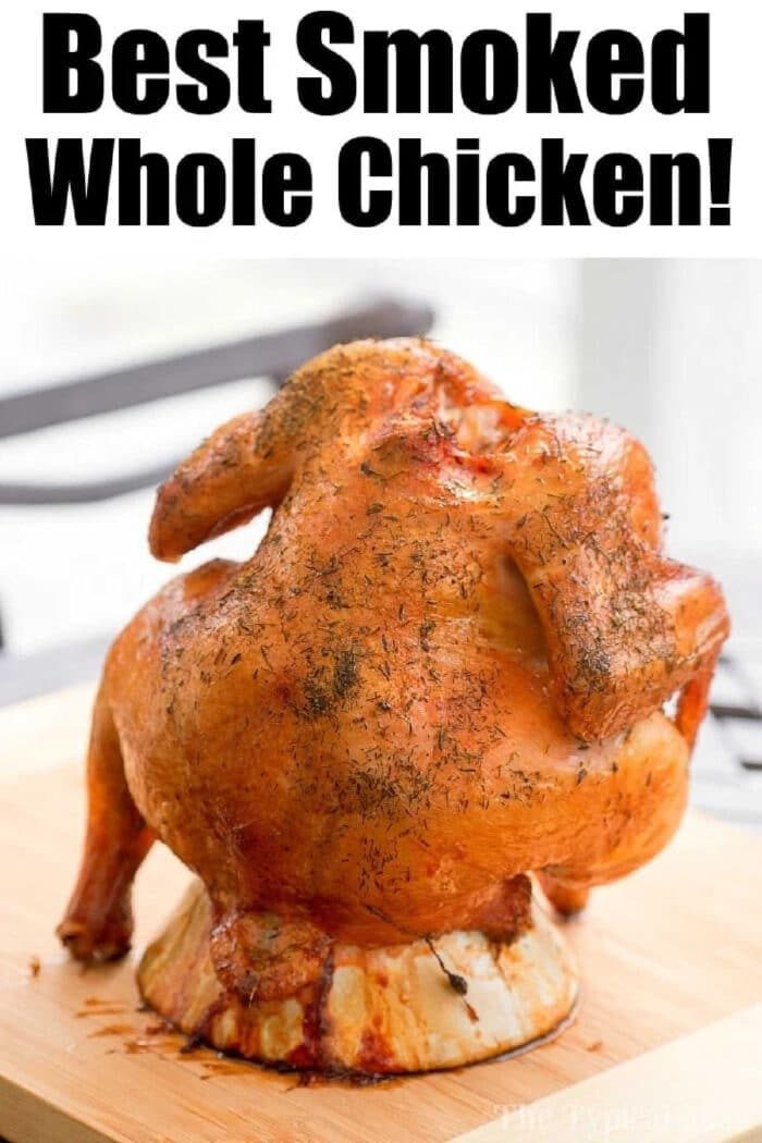 Smoked beer can chicken standing upright on a wooden board with text Best Smoked Whole Chicken! above it.