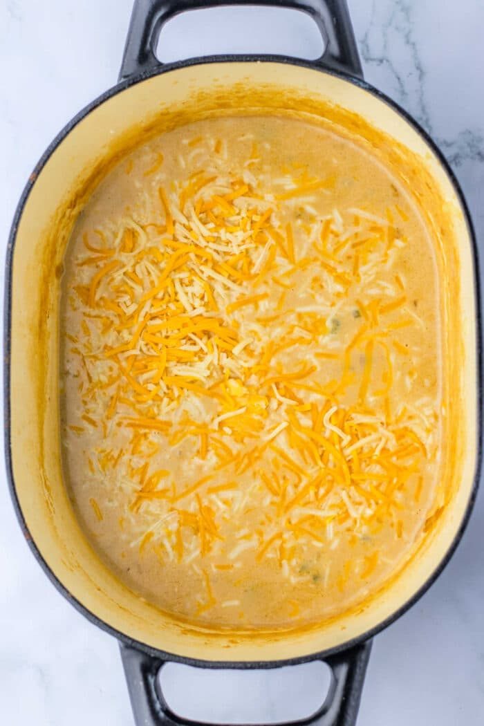 steak soup with melted cheese sits invitingly in an oval dish on a marble surface, reminiscent of the comforting flavors found in a hearty steak and potato soup.