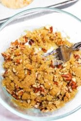 Bowl of crumbly streusel topping with pecans and a fork, solid for your next sweet potato muffin recipe.