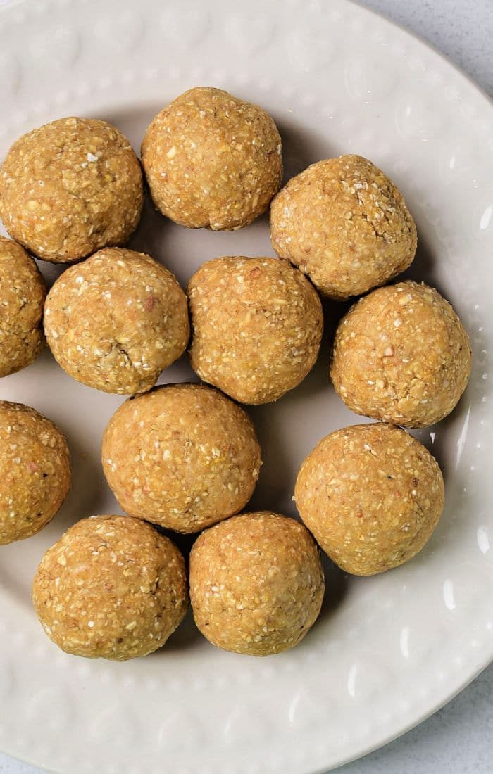 A cream-colored plate displaying round matzo balls homemade