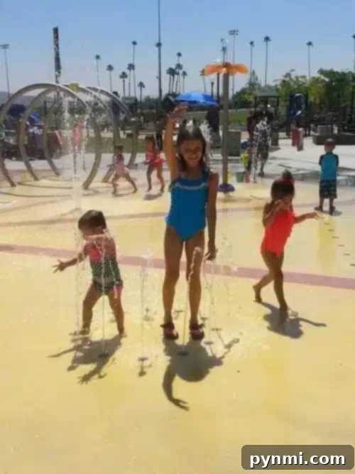 Children playing in various water jets and fountains at Citrus Water Park Corona splash pad