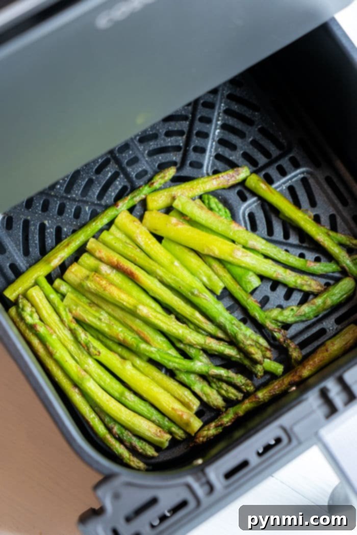 Crispy Air Fryer Frozen Asparagus 7 Crispy air-fried frozen asparagus spears piled in a serving bowl, ready to eat.