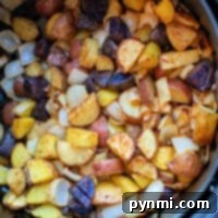 In the black air fryer basket, a medley of roasted potatoes and onions transforms into a savory delight, perfectly highlighting the charm of air fryer cooking.