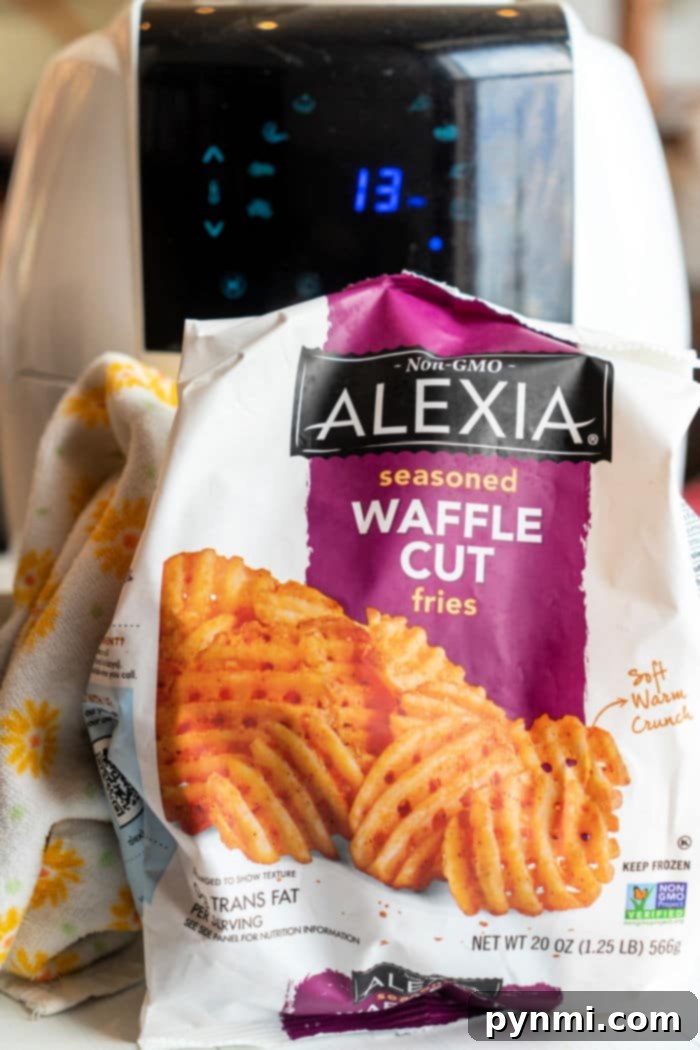 Golden brown waffle fries arranged neatly in an air fryer basket.
