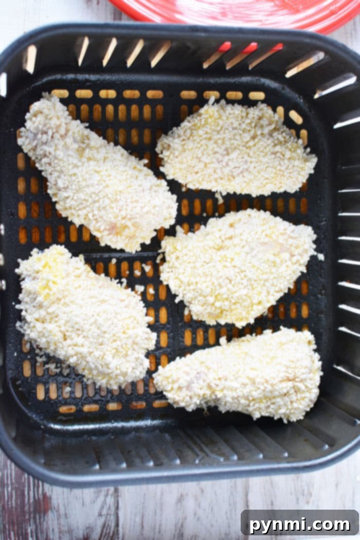 A large serving of crispy gluten-free Panko chicken wings in a bowl, with sauces in the background.