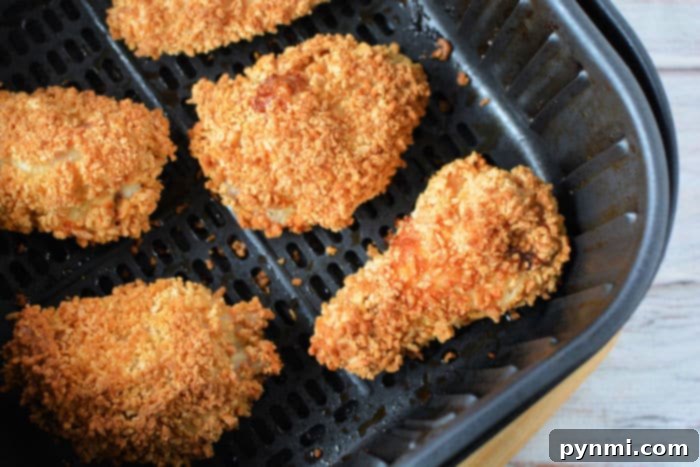 Crispy gluten-free air fryer wings served with fresh parsley and a side of sauce.