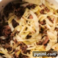 A bowl featuring a delightful sauerkraut recipe with meat includes cooked ground meat and sliced cabbage, lightly browned and perfectly mixed together.