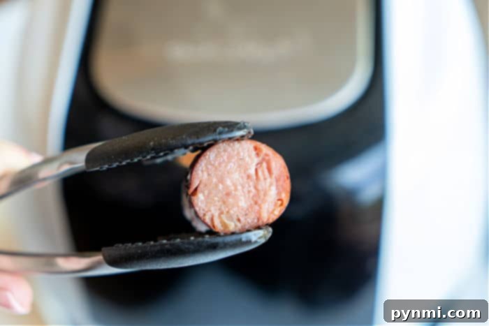 Ninja Foodi frozen sausage cooking in the air fryer basket.