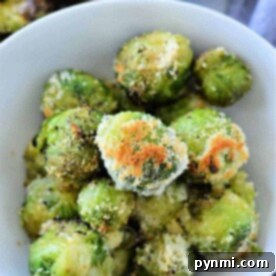 A bowl of perfectly roasted Brussels sprouts, skillfully transformed from their frozen state, is topped with golden breadcrumbs and flavorful seasoning.