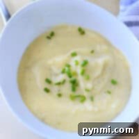 A bowl of creamy mashed potatoes topped with chopped chives brings the comforting essence of an Instant Pot Potato Leek Soup to your table.