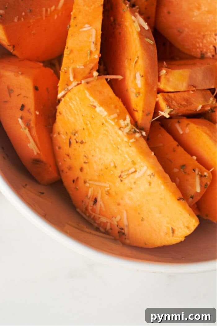 Crispy Air Fryer Sweet Potato Wedges 4 Sweet potato wedges in an air fryer basket, ready to be cooked
