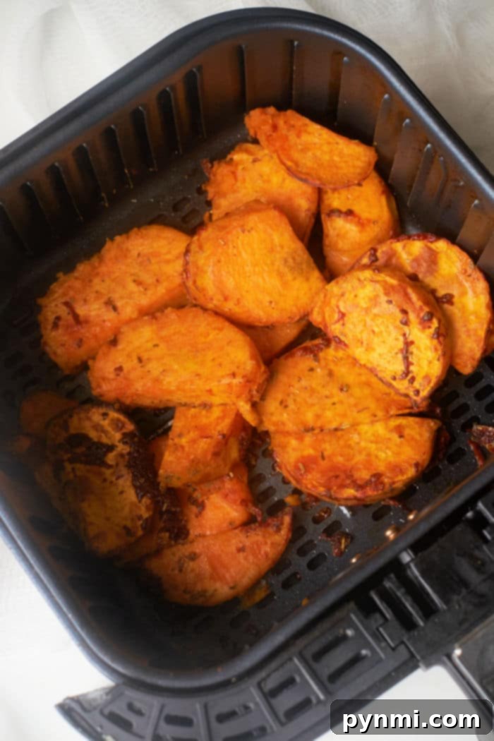 Crispy Air Fryer Sweet Potato Wedges 6 Crispy Air Fryer Sweet Potato Wedges piled on a plate with fresh herbs
