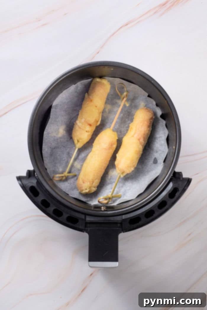 Hot dogs with sticks inserted, ready for dough