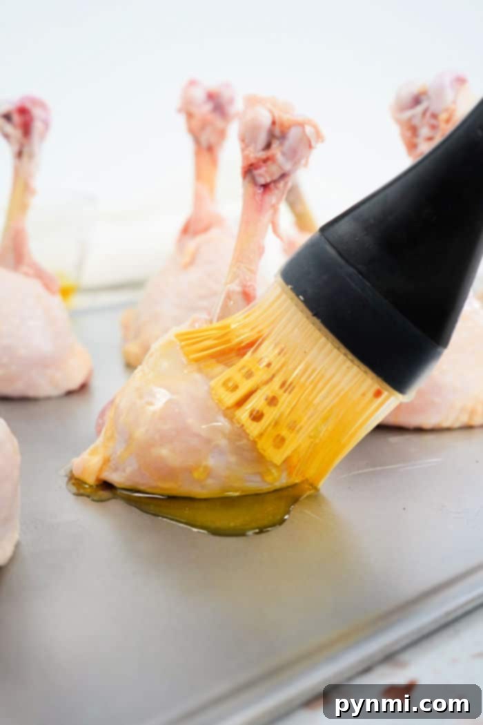 Perfect Lollipop Chicken Drumsticks 9 A cutting board with a selection of chicken drumsticks, some already lollipopped and ready for seasoning, highlighting the preparation process.