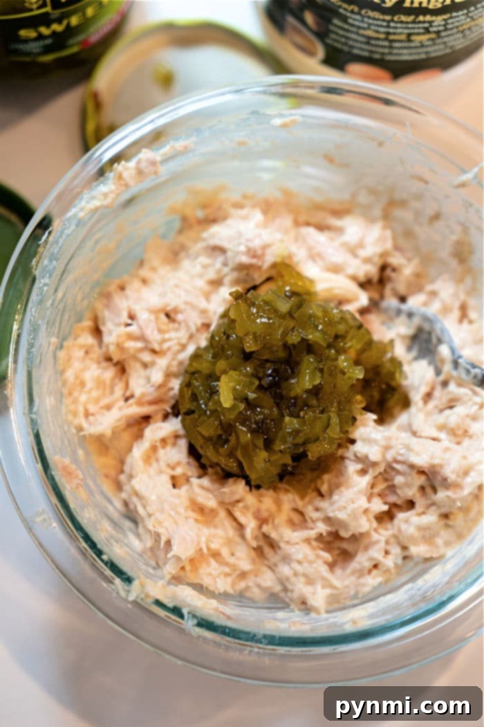 Crispy Air-Fried Tuna Sandwich 9 A close-up of a flavorful, creamy tuna salad mixture in a glass bowl, showcasing the flaky texture of the tuna and well-incorporated ingredients, perfectly prepared for making air fryer tuna melts.