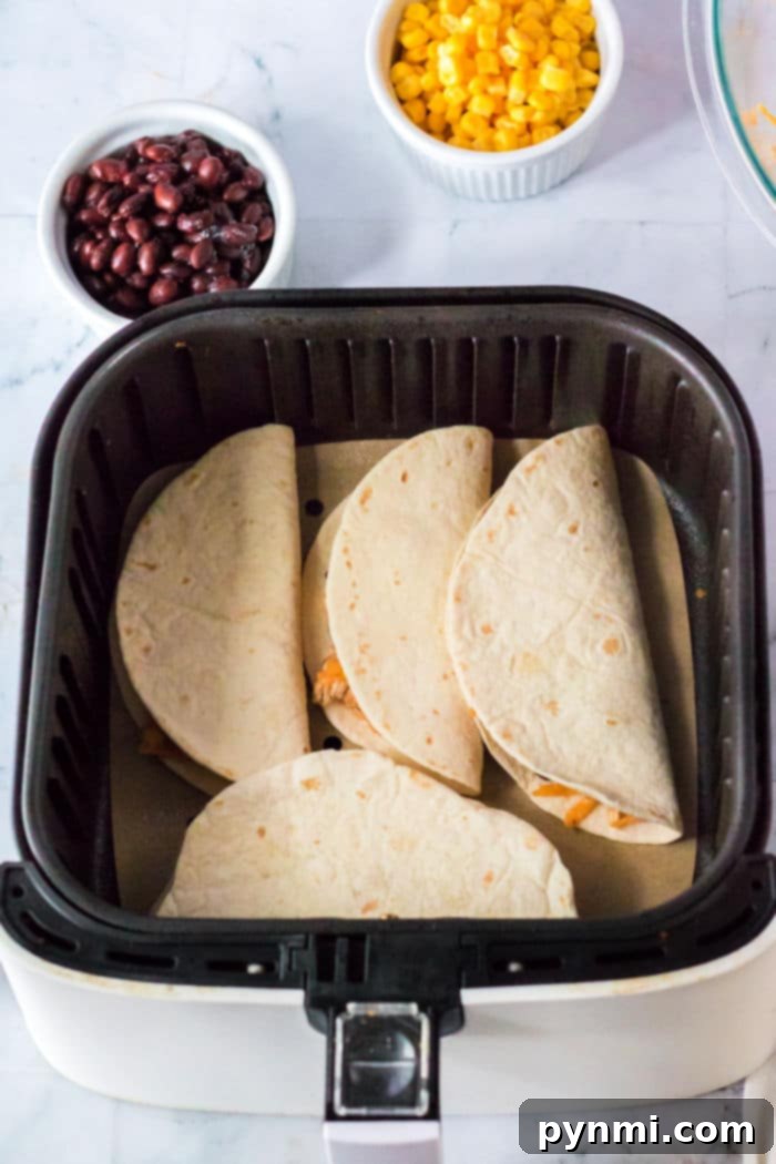 Ninja Foodi Tacos filled with chicken, corn, beans, and cheese, ready for air frying.