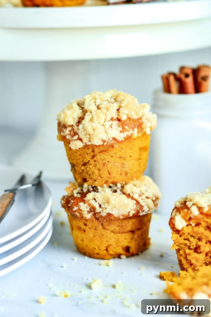 Close-up of baked mini pumpkin muffins on a cooling rack, showcasing their fluffy texture and golden tops.