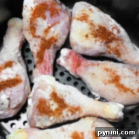 Six raw, seasoned chicken drumsticks, ready to be cooked into delicious Air Fryer Frozen Chicken Legs.