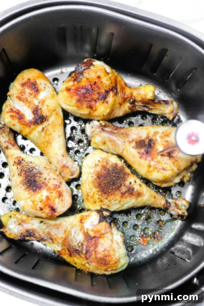 Perfectly cooked Air Fryer Frozen Chicken Drumsticks with golden-brown, crispy skin, arranged neatly in the air fryer basket.