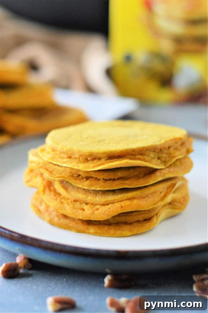 A close-up of freshly cooked Bisquick Pumpkin Pancakes, infused with pumpkin pie mix and ready to be served, showcasing their vibrant color and inviting aroma.