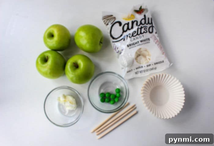 Ghostly White Chocolate Candy Apples 3 Gluten-free candy apples adorned with white chocolate and green edible eyes, ideal for Halloween celebrations.
