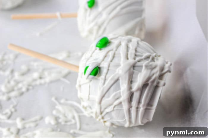 Ghostly White Chocolate Candy Apples 5 Step-by-step image of chocolate covered apples being prepared, showcasing the coating process.