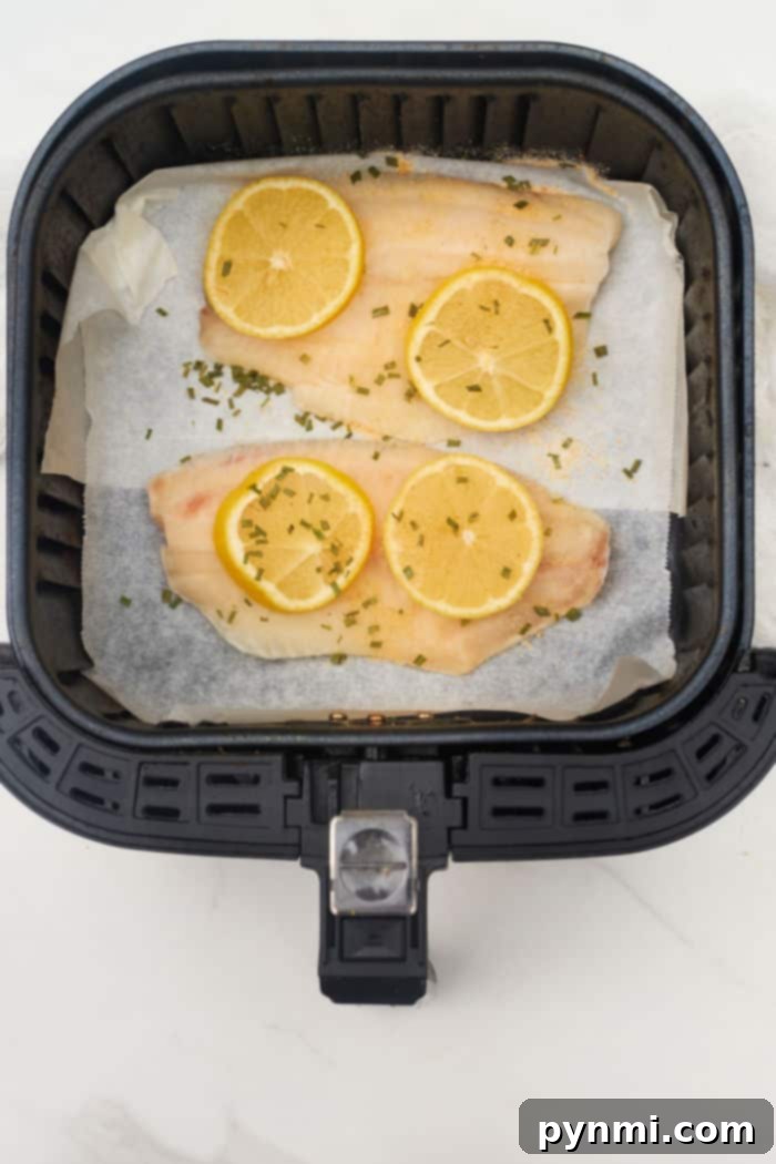 Crispy Air Fryer Frozen Tilapia 5 Perfectly cooked, flaky air fryer frozen tilapia with lemon slices.