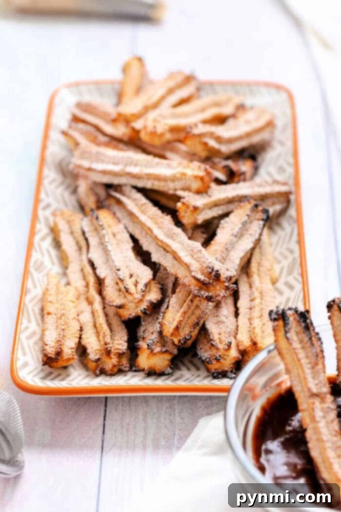 A stunning plate of air fryer chocolate-filled churros, perfectly golden and dusted with cinnamon sugar, ready to be served as a gourmet dessert.