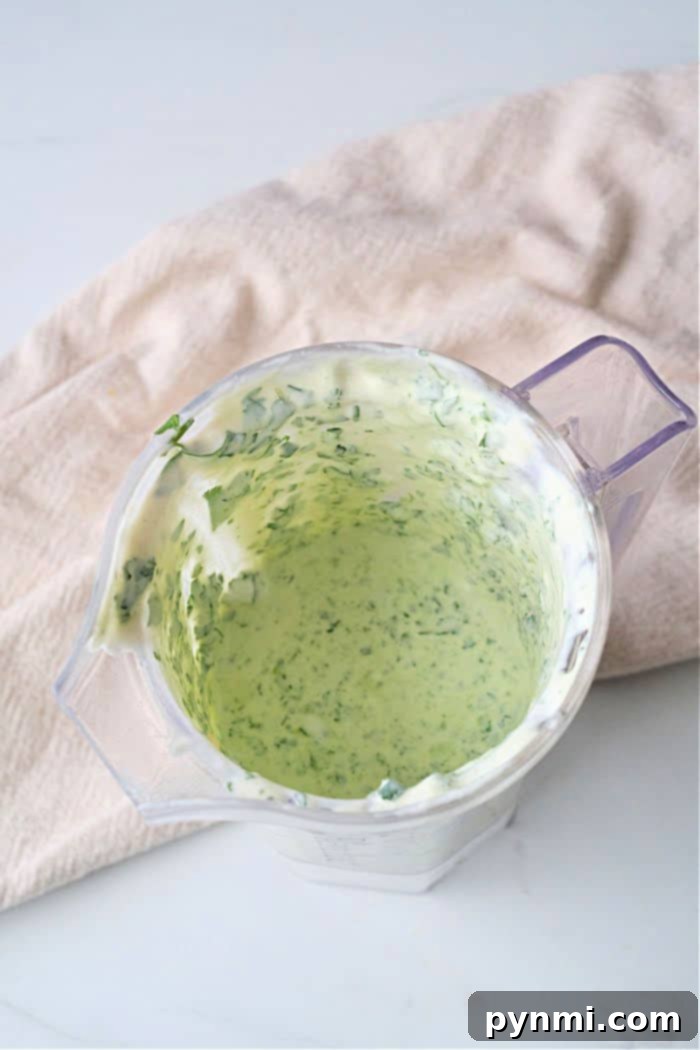 Perfect Dipping Sauces for Sausage Balls 3 A creamy white sausage ball dip garnished with fresh herbs in a ceramic bowl.