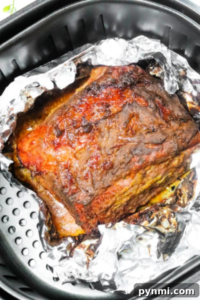 Air Fried Corned Beef Perfection 10 How Long to Cook Corned Beef in Air Fryer - Sliced corned beef on a board with garnishes.