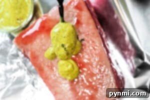 Air Fried Corned Beef Perfection 6 A spoon drizzles yellow mustard sauce over a thick, raw cut of Air Fryer Corned Beef on foil.