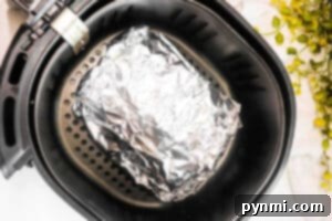 Air Fried Corned Beef Perfection 7 A foil-wrapped Air Fryer Corned Beef sits inside the basket, ready to be cooked to perfection.