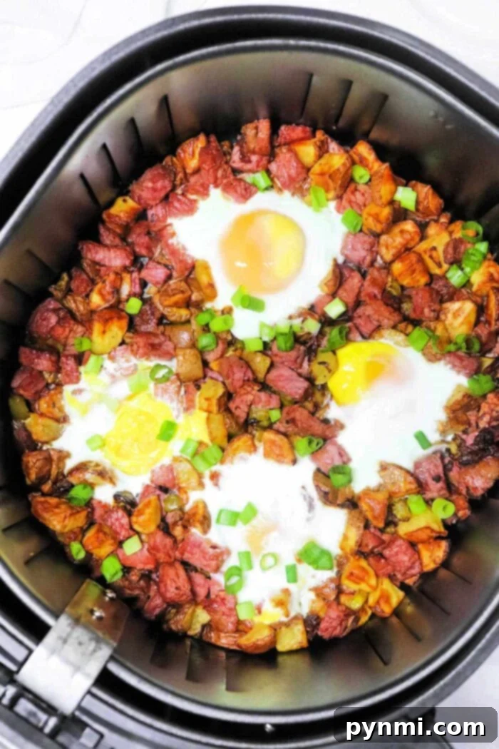 Crispy Air Fryer Corned Beef Hash 9 Air Fryer Corned Beef Hash and eggs on a plate with fresh parsley