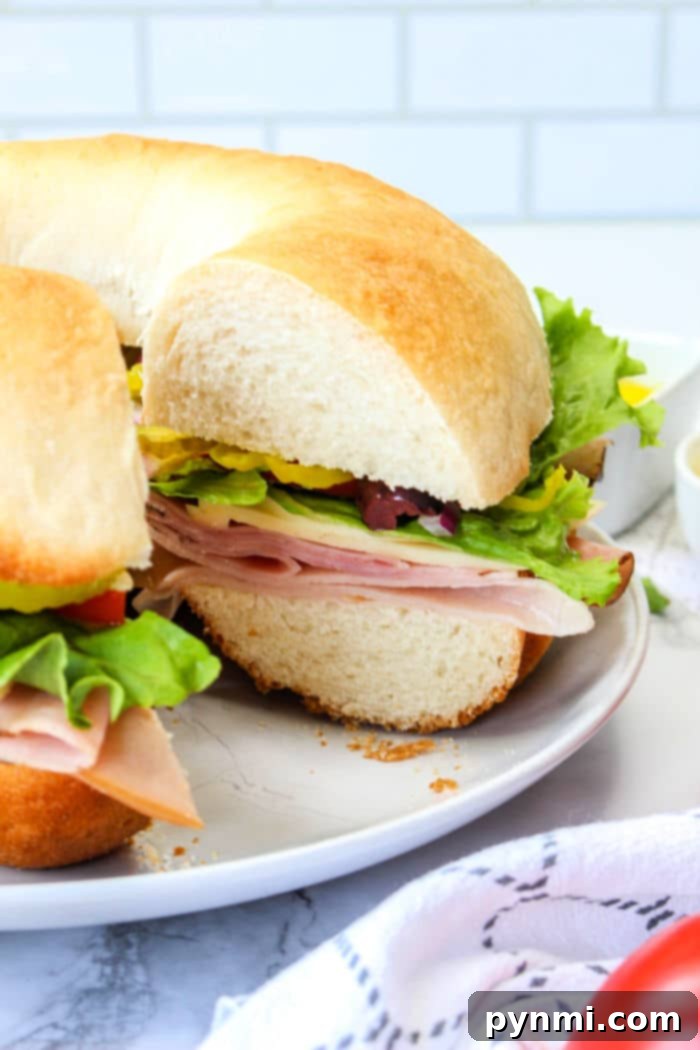 Bundt Witch 7 A sliced bundtwich sandwich with ham, lettuce, and vegetables on a white plate resembles an artisanal take on how to make a bundtwich.