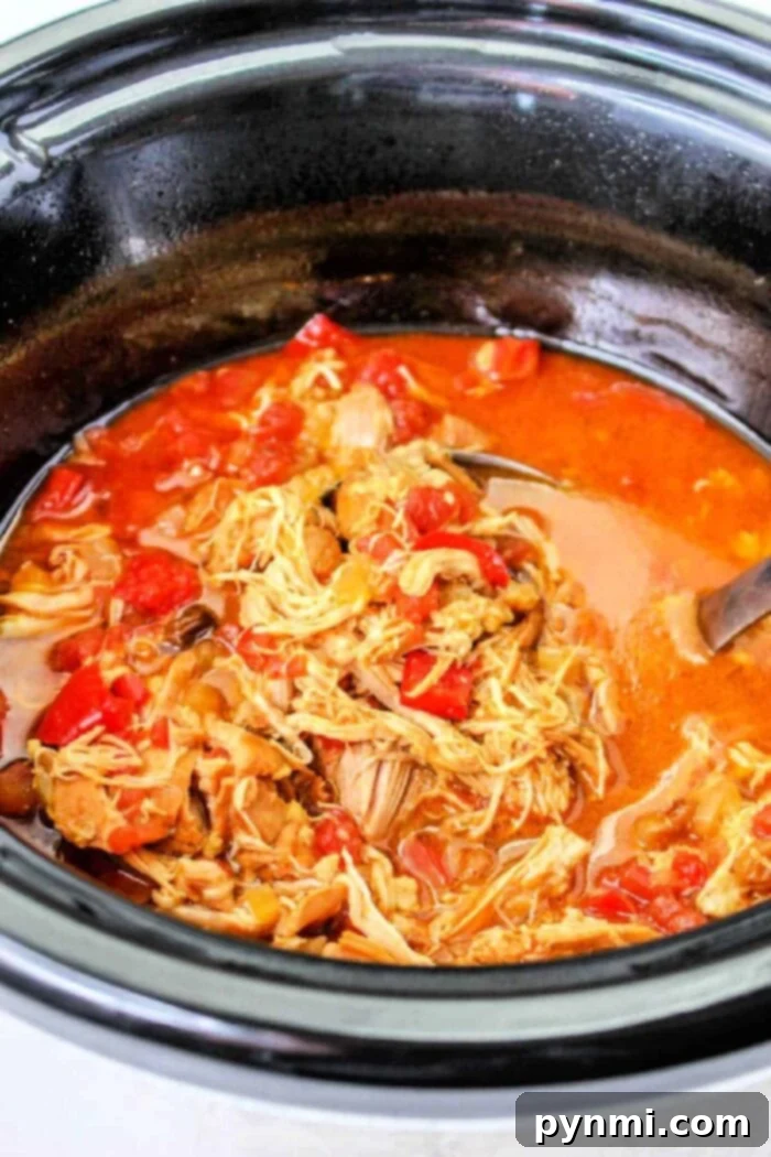 Slow Cooker Mexican shredded chicken with Rotel served with tortillas and lime.