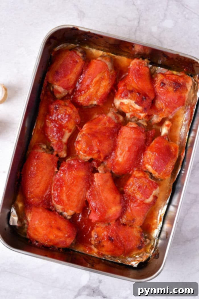 How Long to Bake Chicken Wings at 375°F 6 A tray of baked BBQ chicken wings, glistening with sauce, resting on a marble surface. This visually confirms the perfect cook of chicken wings in oven at 375 degrees, usually 40-50 minutes.