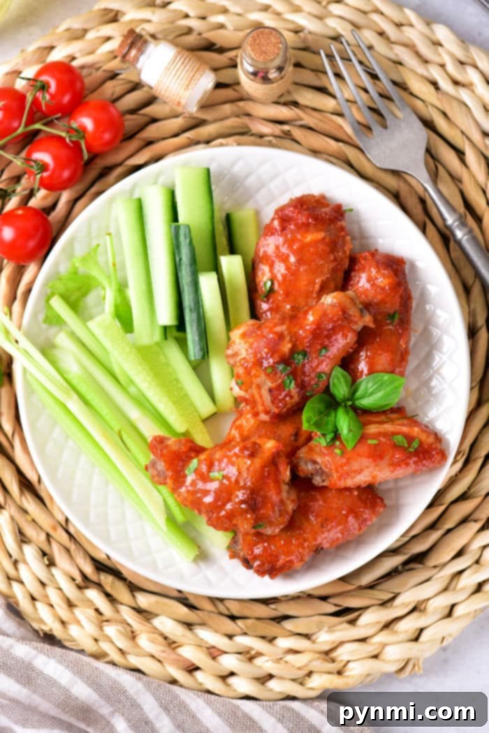 How Long to Bake Chicken Wings at 375°F 7 A close-up shot of perfectly baked BBQ chicken wings, glistening with sauce, showcasing a rich, caramelized finish. An appetizing display of oven-cooked wings at 375 degrees.
