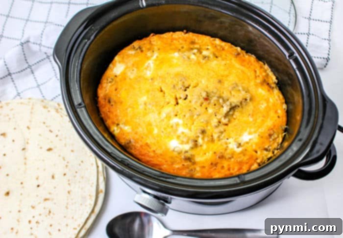 Effortless Slow Cooker Scramble 5 Overhead view of slow cooker scrambled eggs with visible sausage and cheese, indicating a hearty and satisfying breakfast meal.