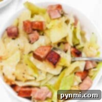 A bowl of savory cabbage and ham stew, perfectly seasoned and ready to enjoy with a spoon.