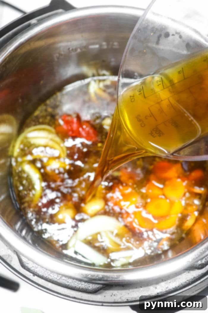 Pouring broth into the Instant Pot, the rich aroma of sliced onions, carrots, and other ingredients fills the air as you start preparing a hearty oxtail soup.