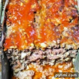 Juicy Meatloaf Without Breadcrumbs 6 Meatloaf without breadcrumbs, featuring a rich tomato glaze, in a pan, partially sliced to reveal its savory interior.
